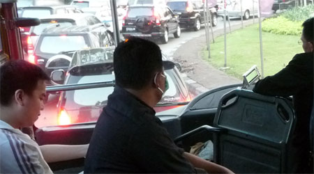 pria bermasker dalam bus kota di jakarta