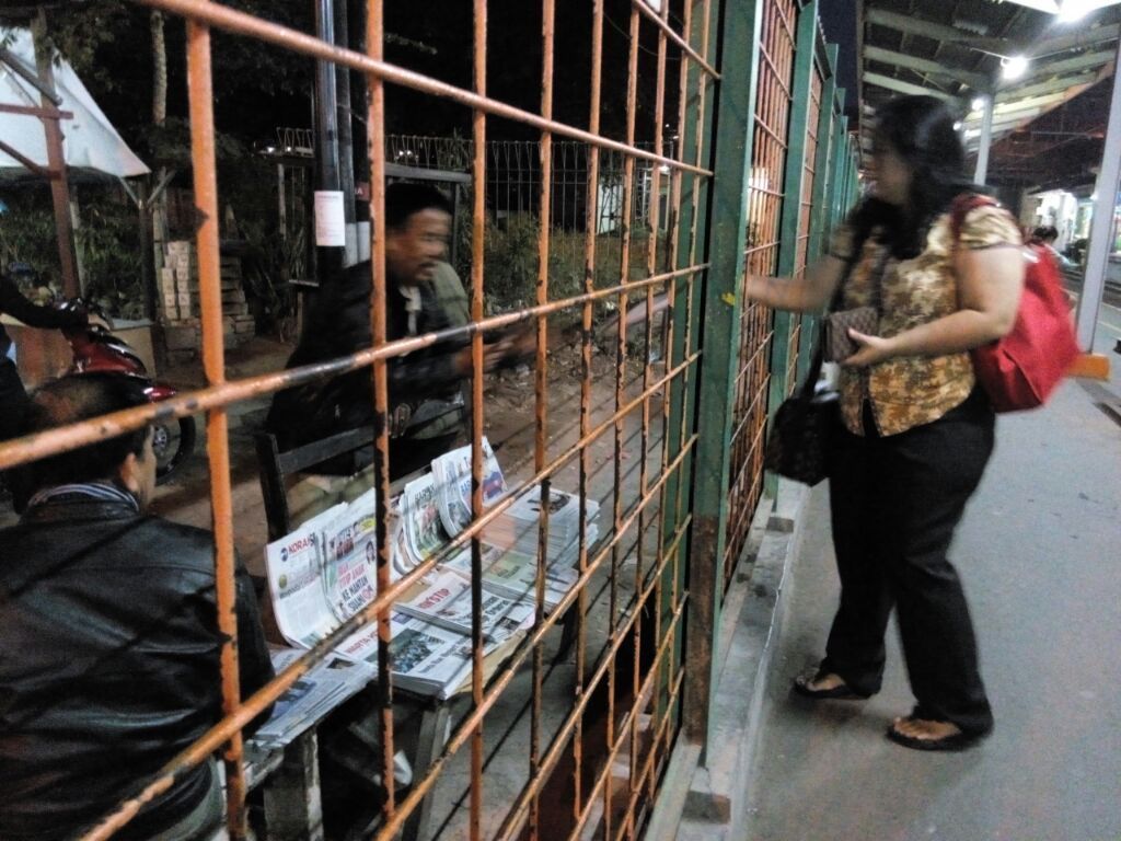 Jual koran dari luar pagar Stasiun Cawang 