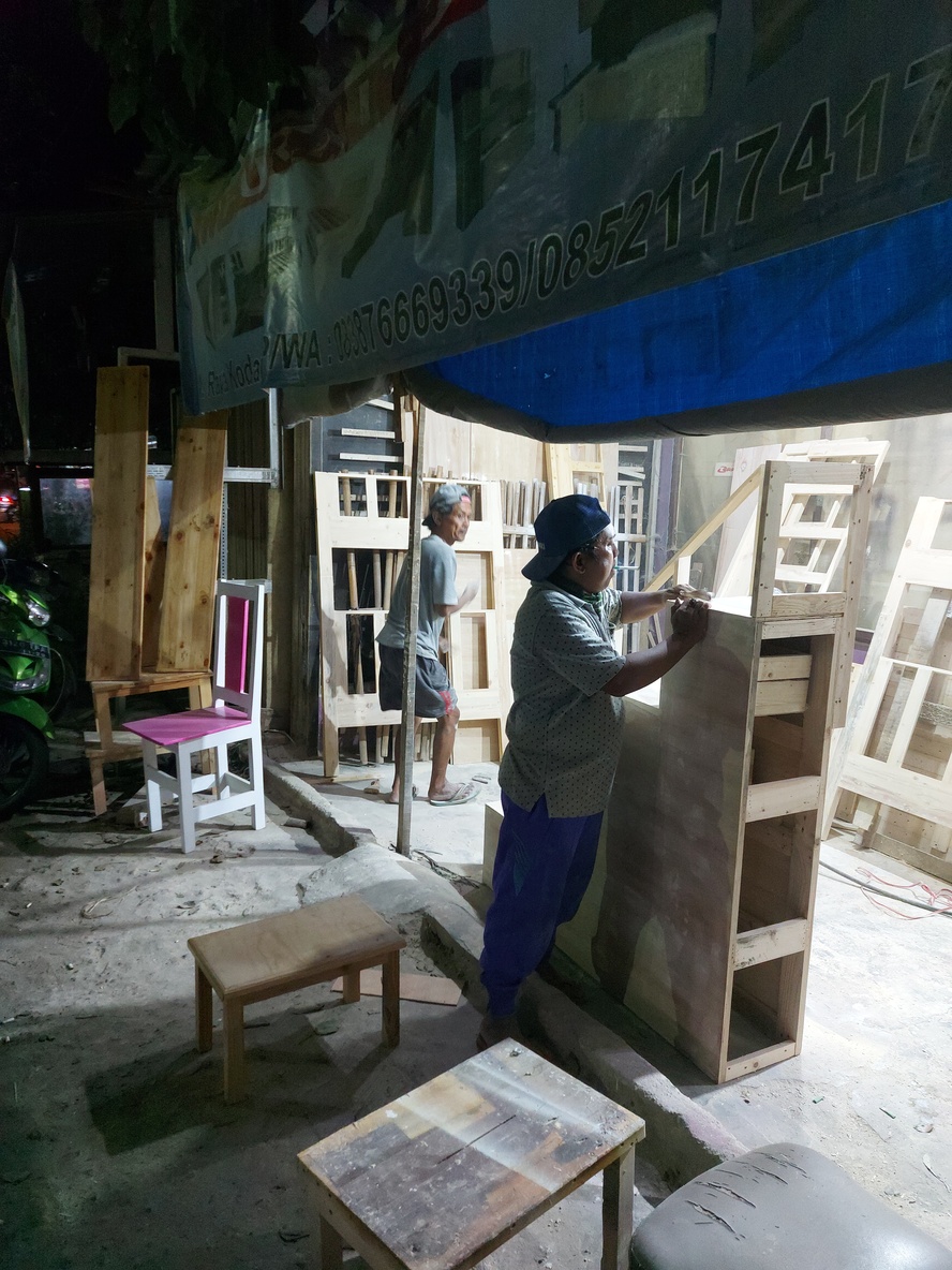 Tukang perabot lembur hingga malam di Jalan Raya Kodau Bekasi 
